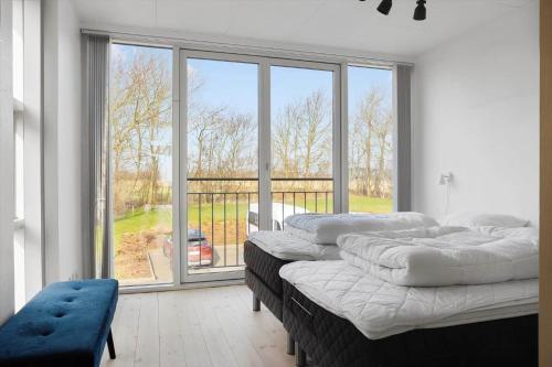 a room with three beds and a large window at LF10214-Thyholm-Havnefronten-14 in Thyholm