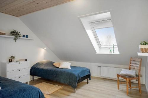 een slaapkamer op zolder met een bed en een raam bij LF10301-Hurup-Thy-Sindrupvej-1-B in Sindrup