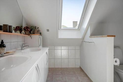 een witte badkamer met een wastafel en een raam bij LF10301-Hurup-Thy-Sindrupvej-1-B in Sindrup