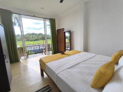 a bedroom with a large bed and a large window at Oasi house in Unawatuna