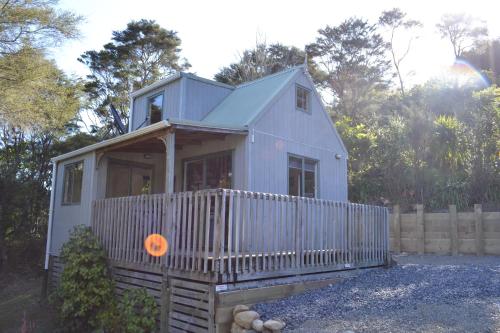 a small white house with an orange pumpkin on the porch at Te Mata Lodge in Tapu