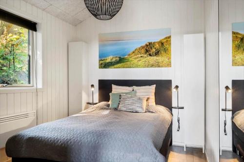 een slaapkamer met een bed en een schilderij aan de muur bij LF11106-Struer-Slugten-6 in Humlum