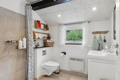 een badkamer met toilet, wastafel en raam bij LF18116-Veslos-Agerovej-6 in Amtoft