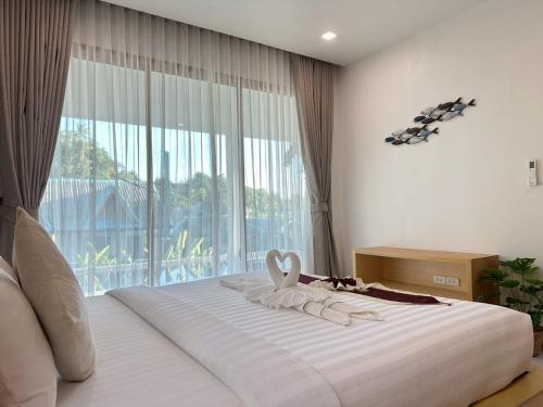 une chambre avec un lit et une grande fenêtre dans l'établissement Sunsea Resort, à Baan Khai