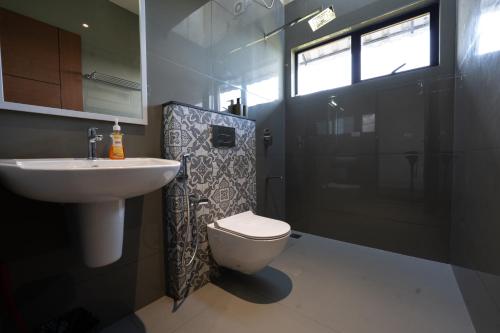 een badkamer met een toilet, een wastafel en een douche bij Windy Cove by bukroom in Pīrmed