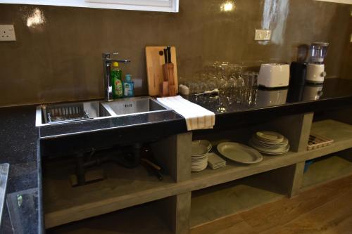 a kitchen with a sink and a counter with plates at Oasi house in Unawatuna