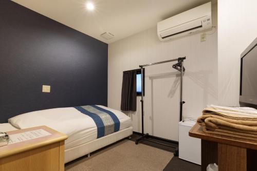 a hotel room with a bed and a tv and a bathroom at Ogaki Hiyori Hotel - Vacation STAY 13930v in Ogaki