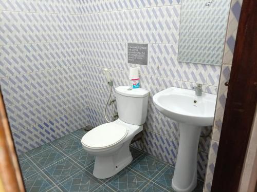 een badkamer met een wit toilet en een wastafel bij Surf Kin Garden Inn in Weligama