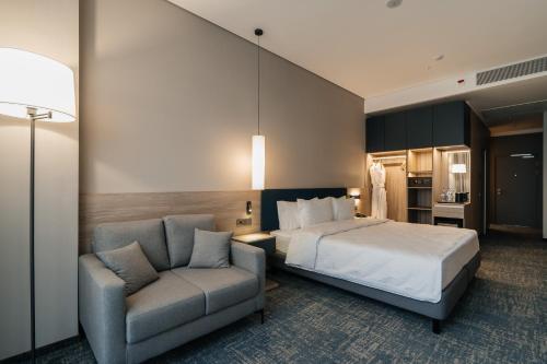 乌拉尔斯克West Plaza Hotel的一间酒店房间，里面有一张床和一把椅子