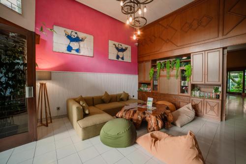 een woonkamer met een bank en een tafel bij Snooze Malang in Malang