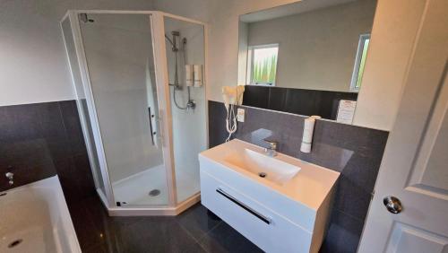 een badkamer met een wastafel en een douche bij Carramar Motor Inn in Palmerston North