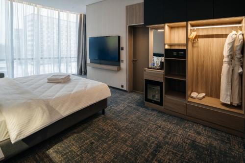 a hotel room with a bed and a flat screen tv at West Plaza Hotel in Oral