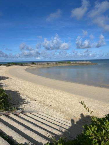 een zandstrand met een waterlichaam bij BARi OKINAWA in Itoman