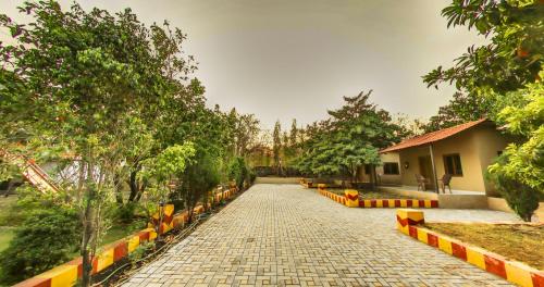 a walkway in a park with trees and a building at Tejas Gir Villas in Sasan Gir