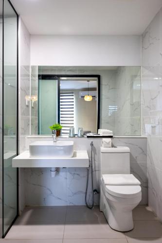 a white bathroom with a sink and a toilet at Kivana Suite, Vetro 11 by Ayuhouz in Kota Kinabalu