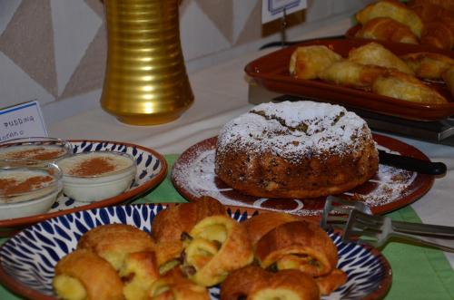 a table topped with plates of food with pastries at Emporios Bay Hotel Chios in Emporeios