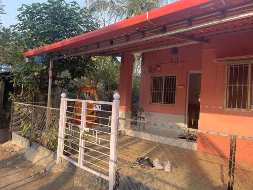 a pink house with a gate in front of it at Golden Wave Cottage in Revadanda