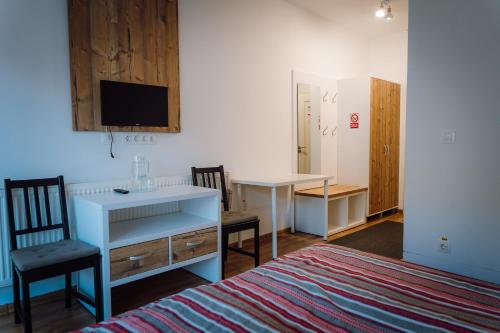 a room with a bed and a desk and a desk at Double room in Pensiunea Nossa Panzió in Corunca