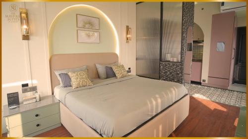 a bedroom with a large bed with an arch above it at The Mayfair Suites by AURACHE in Greater Noida