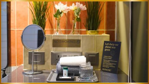a bathroom with a mirror and a pile of towels at The Mayfair Suites by AURACHE in Greater Noida