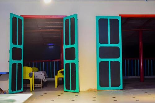 een kamer met twee open deuren en twee gele stoelen bij Nomads Beach Resort in Clifton