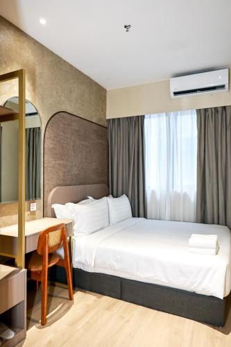 a hotel room with a bed and a desk at Kivana Suite, Vetro 11 by Ayuhouz in Kota Kinabalu