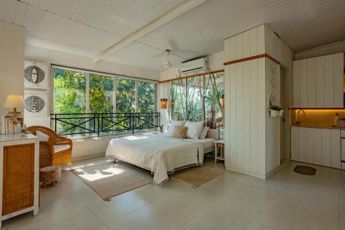 ein Schlafzimmer mit einem Bett und einem großen Fenster in der Unterkunft Kenwood's Farmstay - 6bhk with private pool in Zadapoli