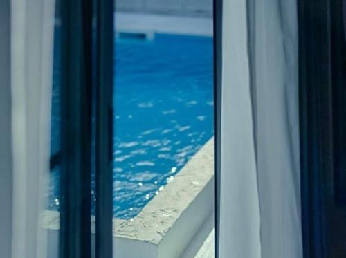 een uitzicht op de oceaan vanuit een raam van een gebouw bij RYUKYU BREEZE 1棟貸し 天然ビーチまで徒歩30秒 プライベートプール付きVilla 北部 in Nago