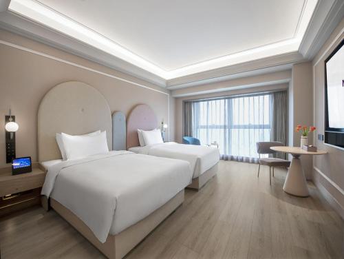 a hotel room with two beds and a television at Mercure Chengdu Dongjiao Memory in Chengdu