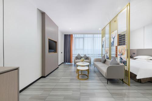 a hotel room with a bed and a couch at Good East Hotel in Guangzhou