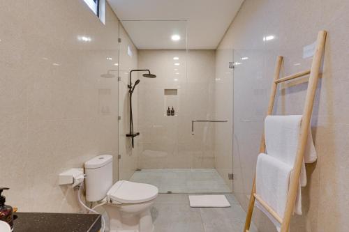 a bathroom with a shower and a toilet in it at Bhatara Villa Sanur in Sanur