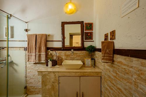 ein Badezimmer mit Waschbecken und Spiegel in der Unterkunft Kenwood's Farmstay - 6bhk with private pool in Zadapoli