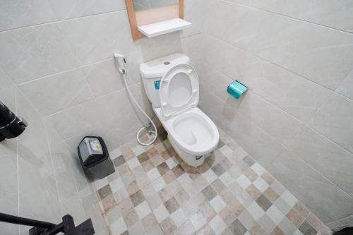 een badkamer met een wit toilet in een stal bij Villa Aruna Kolam Renang Private in Godean