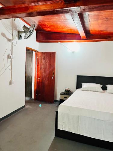 a bedroom with a bed and a wooden ceiling at Azure Coast Villa in Ahangama