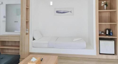 een witte slaapkamer met een bed en een salontafel bij Sawasdee Coco Resort in Ko Samed