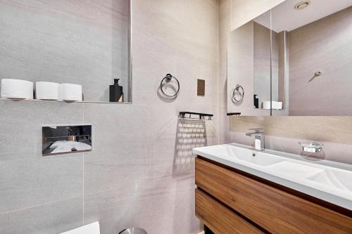 a white bathroom with a sink and a mirror at Private room in BURJ KHALIFA facing 3BR luxury apartment in Downtown Near Dubai Mall Metro in Dubai