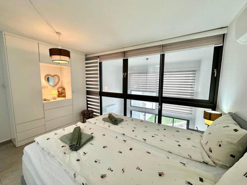 een slaapkamer met een groot bed en een groot raam bij Retreat, block B1, unit15 in Küçükerenköy