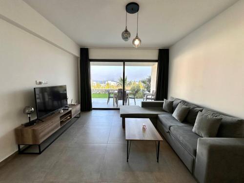 een woonkamer met een bank en een tv bij Retreat, block A2, unit 1 in Ayios Nikolaos