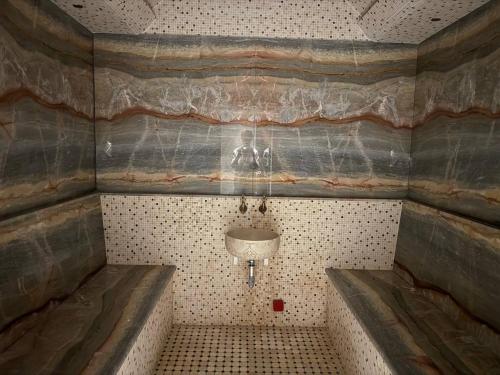 a small bathroom with a sink and a tub at Afrosiyob Regency Hotel in Stantsiya Kyzyl-Tukumachi