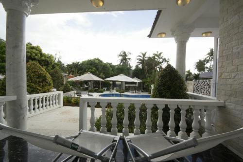 a hammock on a porch with a view of a pool at Godiva Villa Phu Quoc in Phu Quoc