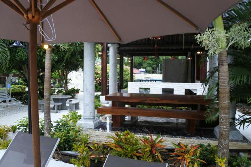 a picnic table and a bench under an umbrella at Godiva Villa Phu Quoc in Phu Quoc