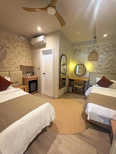 a bedroom with two beds and a mirror at TWIN PALMS 'Beach House' - New surf front location in Thulusdhoo