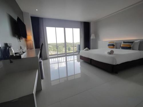 een slaapkamer met een groot bed en een groot raam bij Chaisaeng Villa in Sing Buri