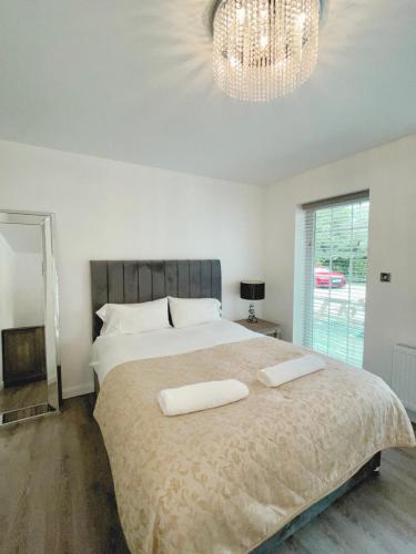 een slaapkamer met een groot bed en 2 witte handdoeken. bij Old Mill Tiny Homes in Kirk Leavington