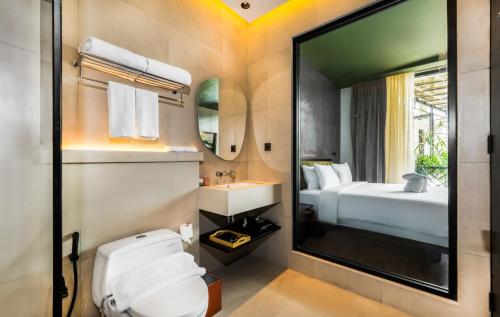 een badkamer met een wit toilet en een wastafel bij Maha Resort Bali in Pererenan