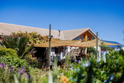 een huis met een beige parasol ervoor. bij New Wave Village in George