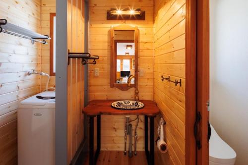 a bathroom with a sink in a wooden cabin at Chalet GOROU in Hakuba