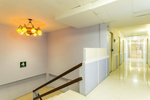 a hallway in a building with a staircase and a chandelier at Roma Hotel in Khon Kaen