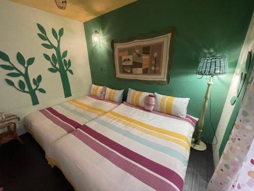 ein Schlafzimmer mit einem Bett und einer grünen Wand in der Unterkunft House Lane 123 in Tainan