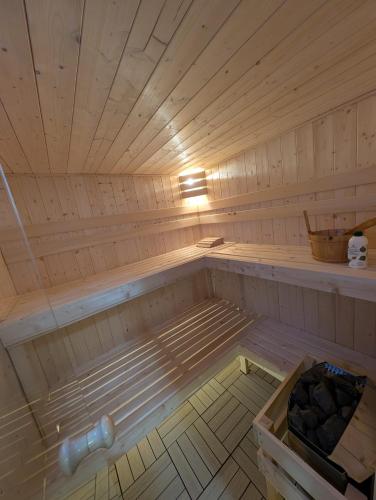 a wooden sauna with a light on top of it at Sowi Kąt - Domki z Baliami oraz Tradycyjne in Lubiatowo